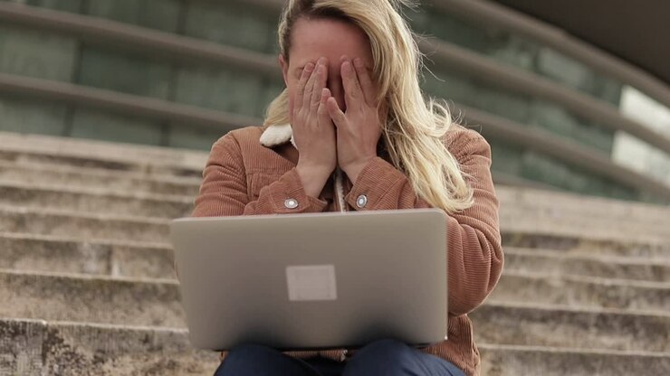 Overworked blonde mature businesswoman working with laptop