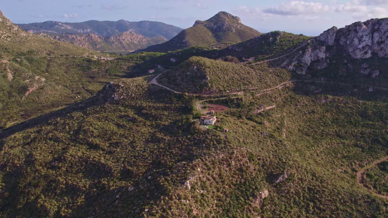 tomada panorámica de una pequeña casa rodeada de montañas en mallorca, islas baleares, aero