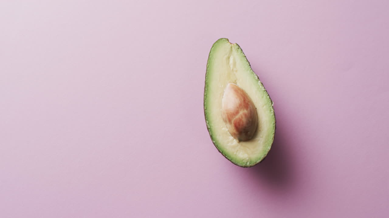 Video di avocado a fette con spazio per il testo su sfondo rosa