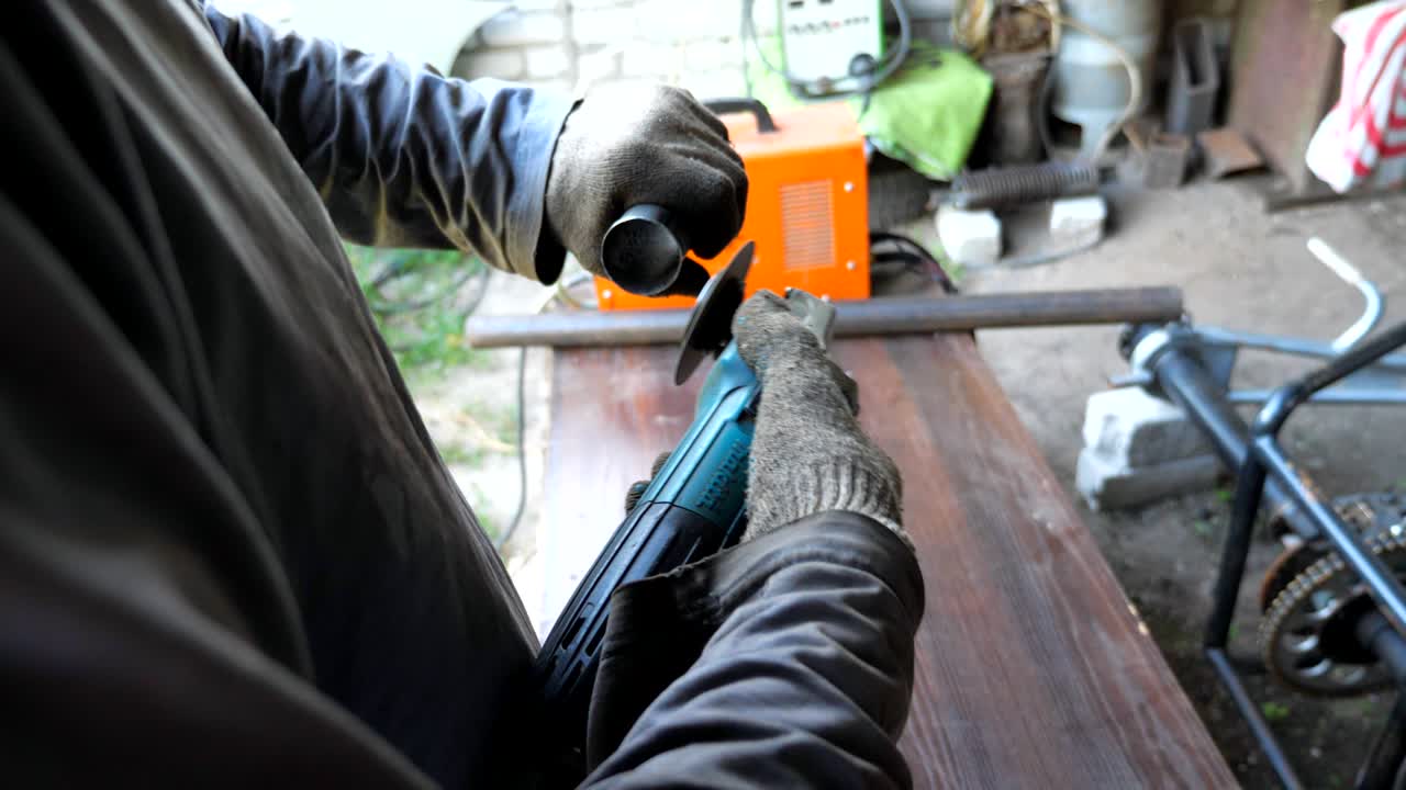 회전 을 사용하여 금속 세부 사항을 날카롭게하는 인식 할 수없는 수리업자 또는 기계. 차고 또는 작업장에서 일하는 사람. 장갑을 입은 노동자. 는 바와 함께 철을 는. 느린 동작. 근접.