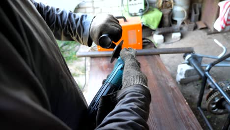 reparador o mecánico irreconocible afilando detalles metálicos usando sierra circular. hombre trabajando en garaje o taller. trabajador con guantes moliendo hierro con rueda de molienda. movimiento lento de cerca