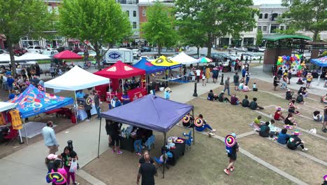 crowd of people at town center park during annual tacos and tequila 5k race in suwanee, georgia, united states. wide shot