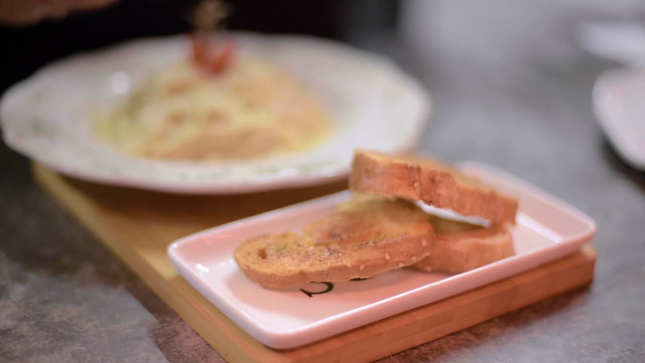 Chef sou-chef cook decorating carbonara spaghetti with fresh parsley at a local restaurant diner cafe in Mexico latin america