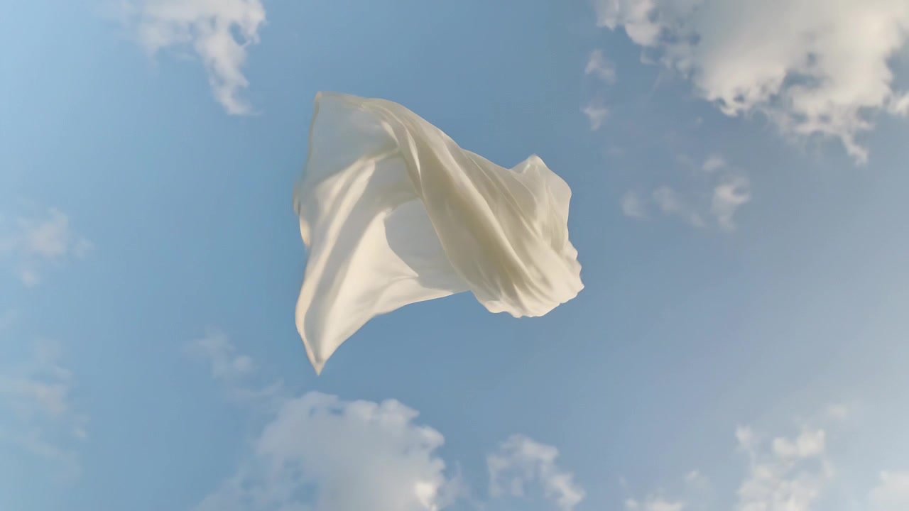 散らばった積雲が浮かぶ青空の下、そよ風に吹かれて白い布が舞い、回転している様子。