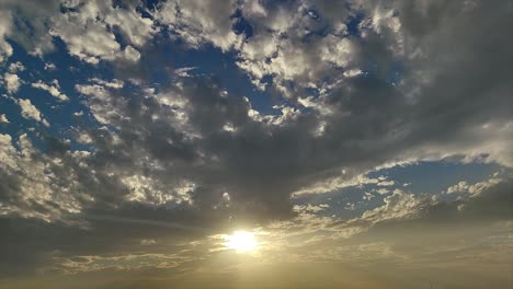 epic timelapse showing golden sunrise light piercing through fast-moving dramatic clouds. ideal for cinematic transitions, nature documentaries, weather visuals and inspiration themes.