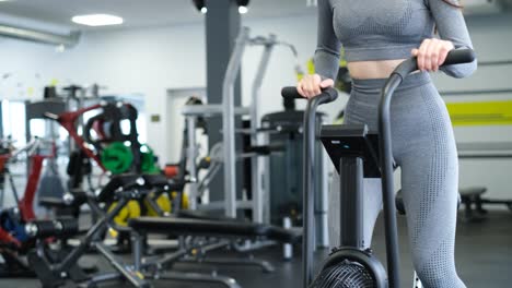 active woman spinning air bike in gym brunette female training on air bike in slow motion f active woman spinning air bike in gym brunette female training on air bike in slow motion fitness girl working in gym