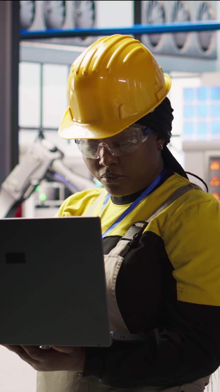 Vertical video Portrait of smiling solar panels factory engineer analyzing data on laptop