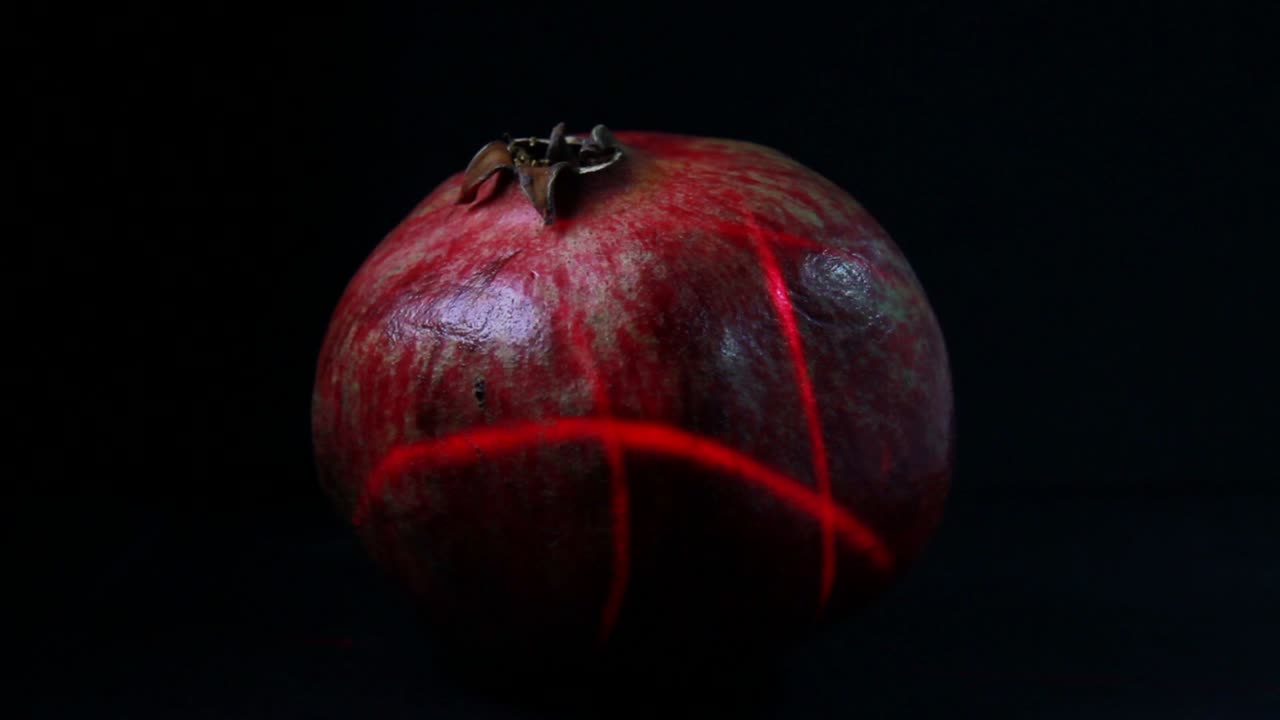 Masser af laserlys scanner granatæblefrugten i mørket