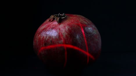 lots of laser light scans the pomegranate fruit in the dark