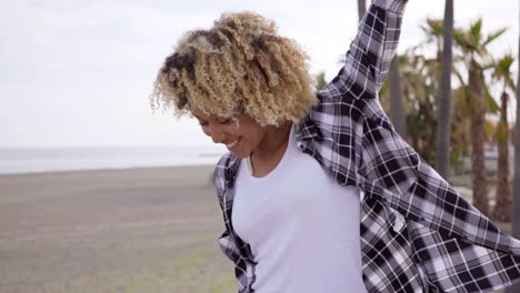 mujer joven caminando en una playa con una patineta