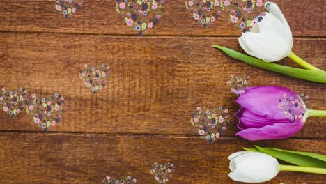 animación de corazones de flores flotando sobre una superficie de madera con tulipanes blancos y rosados