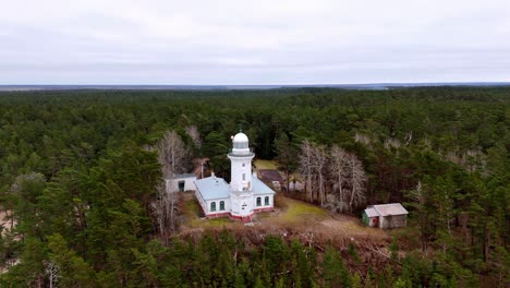 a lighthouse is in the middle of a forest, baltic sea uzava