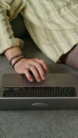 person working on a laptop on a couch.