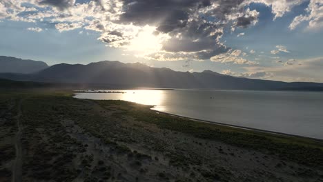 tranquil ocean and mountains against cloudy blue sky - aerial drone shot