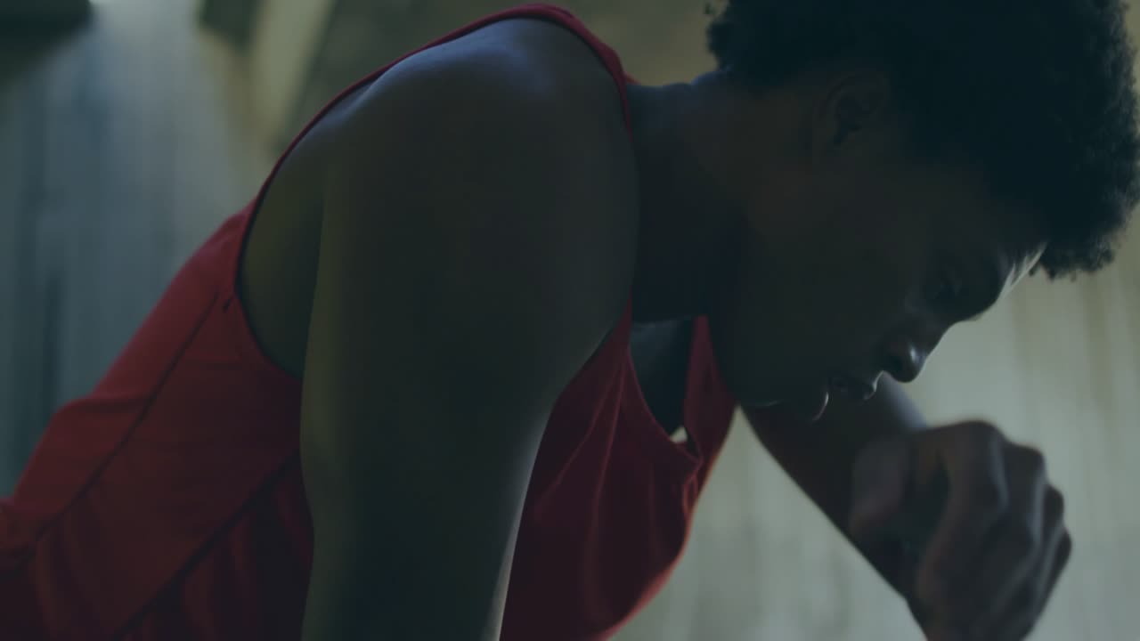 Male athlete pausing after workout, lowering arm, steadying breath, glitch overlays tracking breath