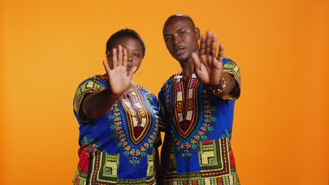 Serious-african-american-couple-show-stop-sign-on-camera