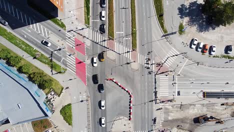 Coches-Conduciendo-En-Una-Intersección-En-Una-Ciudad-Ocupada,-Vista-Aérea-De-Arriba-Hacia-Abajo