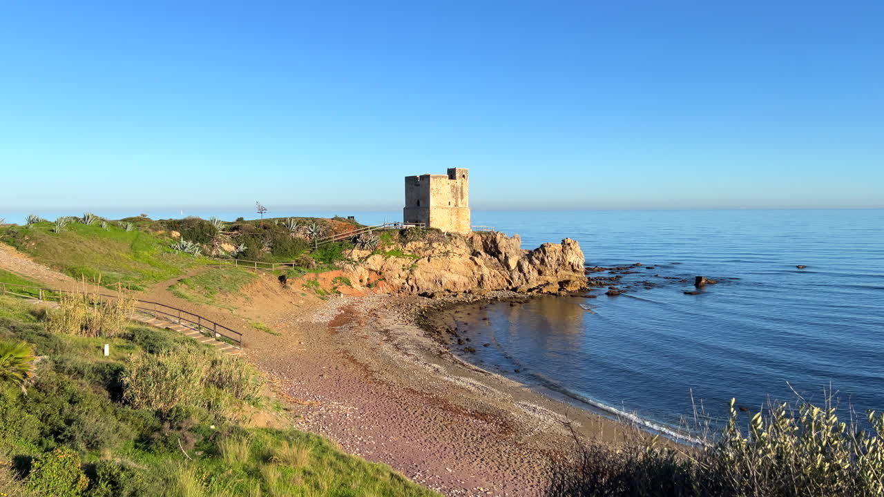 torre de la sal en casares playa de manilva en españa, sistema de torres costeras para la vigilancia y defensa contra los piratas bereberes, plantas verdes en la playa soleada, tiro de 4k