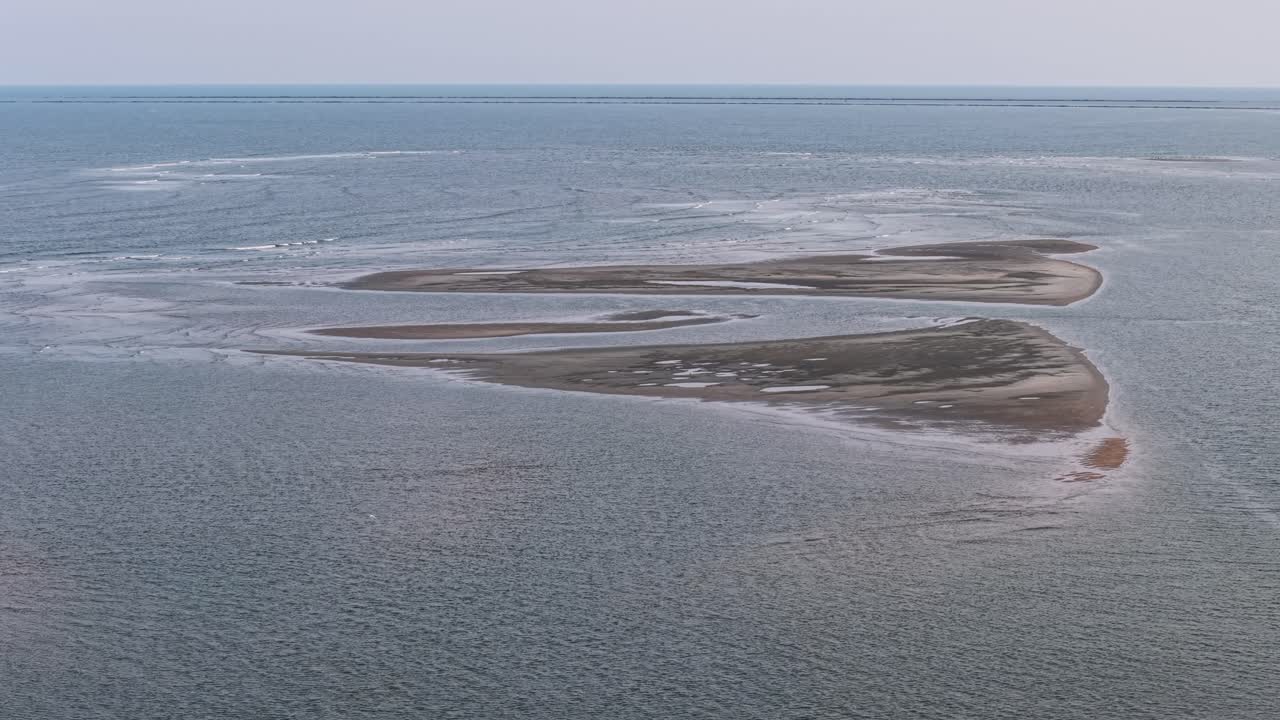 Aerial drone footage shows a small sandbar island in the Charleston waters surrounded by rippled blue water and open horizon