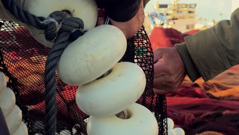 a person is working on a fishing net, cutting them into pieces