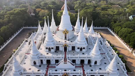 4k aerial pan backward above the wat asokaram temple at sunset in bangkok, thailand