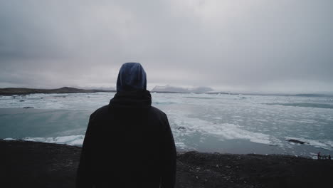 person contemplating iceland's ice lagoon
