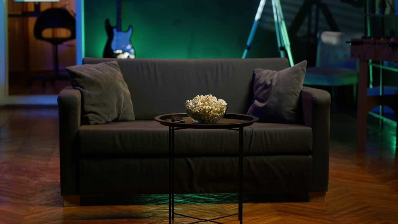 un plato de palomitas de maíz en la mesa en un apartamento de cine en casa iluminado con neón