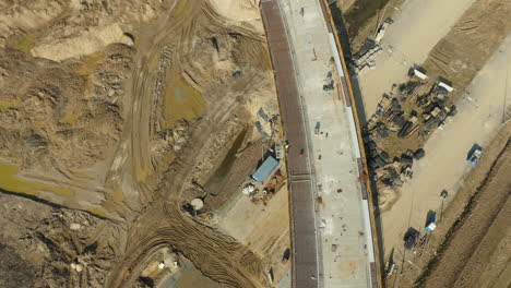 aerial top down - construction of a bridge over a dirt excavation site