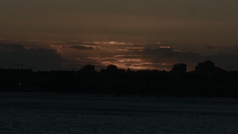 silueta de ciudad con hermosa puesta de sol en el fondo