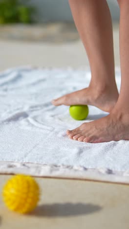 foot massage with massage ball on towel