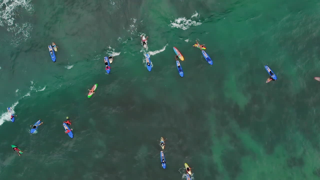 열대 섬 근처의 많은 서퍼들의 하향식 전망