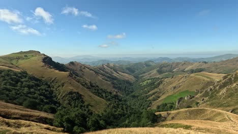 rugged green mountain range landscape extends to distant sunny horizon