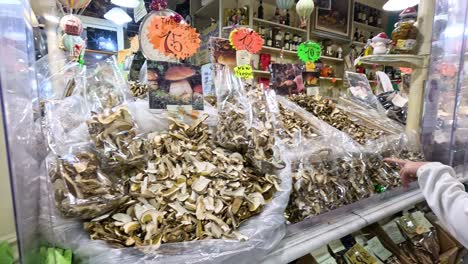 shoppers browse fresh mushrooms at a market