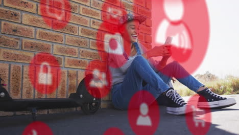 animation of social media icons over biracial woman using smartphone