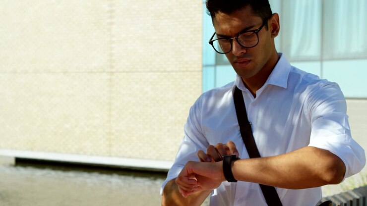 Man in spectacles using smartwatch 4k