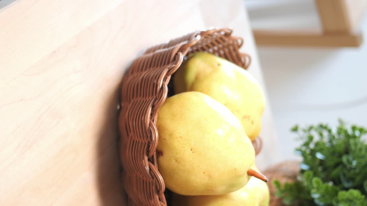Yellow Pears in a Wicker Basket on a Wooden Table