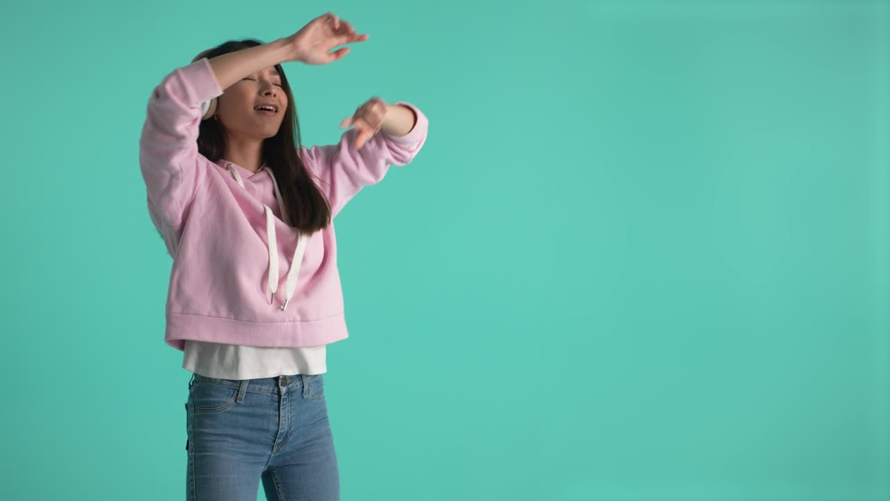 헤드폰을 쓰고 음악에 맞춰 춤을 추는 예쁜 아시아 소녀