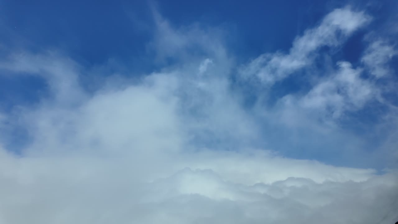 An aerial Pilot POV from a jet cockpit breaking through storm clouds into a deep blue clear sky Ultra-realistic 4K scene.