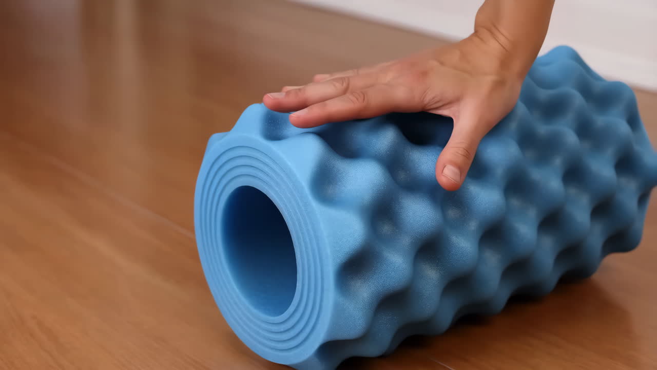 Hand on a Blue Foam Roller for Muscle Massage and Recovery