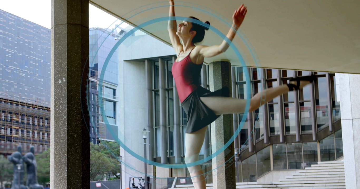 Dancer starting on pointe beneath canopy, training ballet while blue rings encircle torso and arms