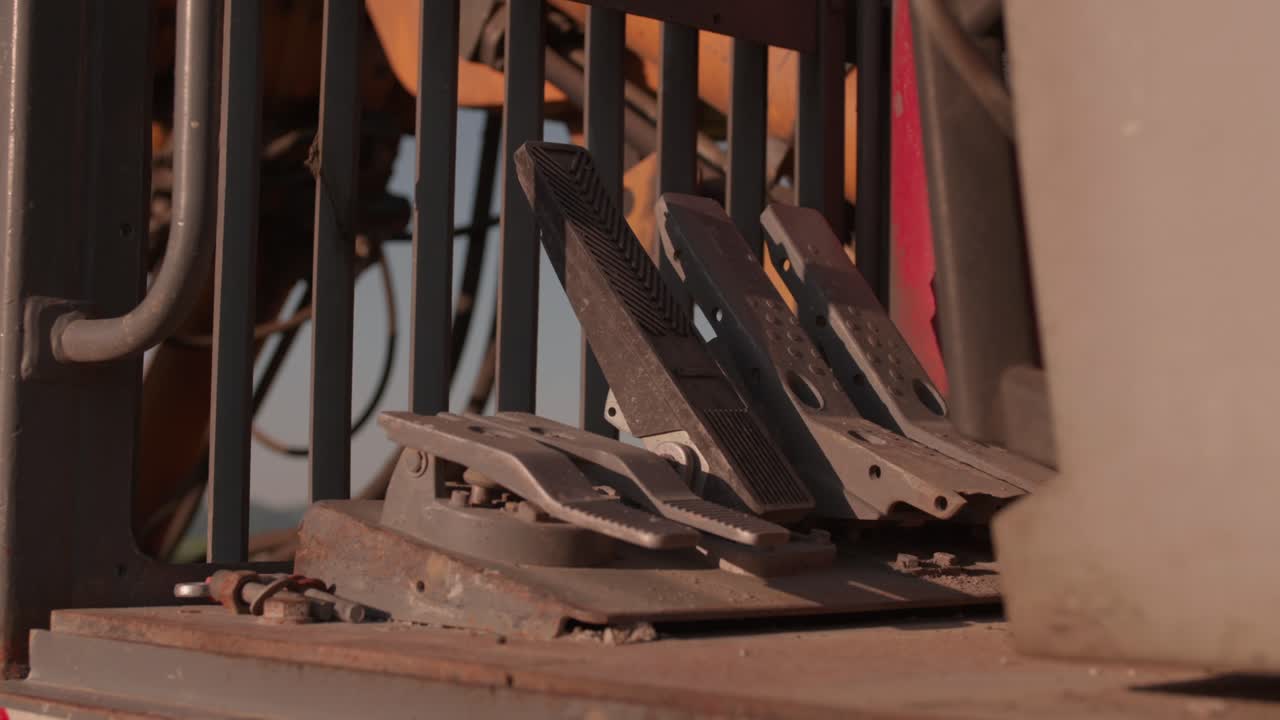 control pedals in the cab of a broken excavator on golden hour