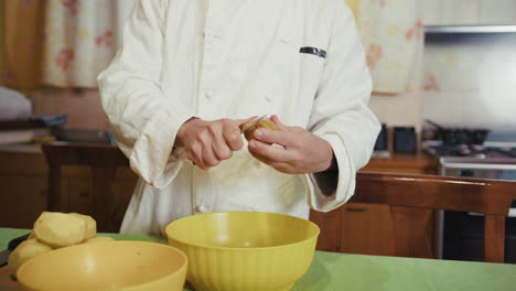 kitchen helper man peels potatoes before service at traditional restaurant