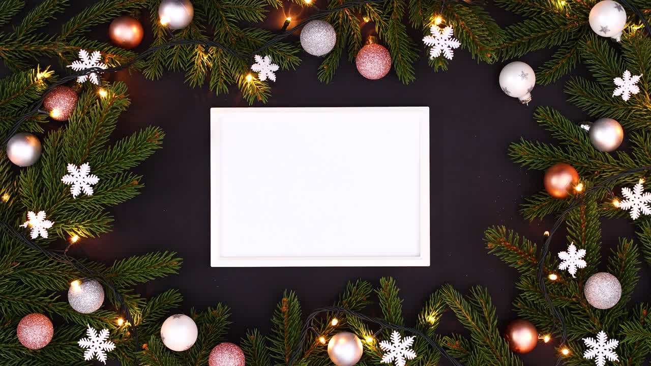 luces parpadeantes en la guirnalda de navidad y marco blanco para el texto en el tema negro.