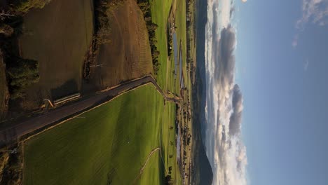 carretera rural de 4k60 en australia con campos verdes, tasmania al atardecer, vista de drones del paisaje rural
