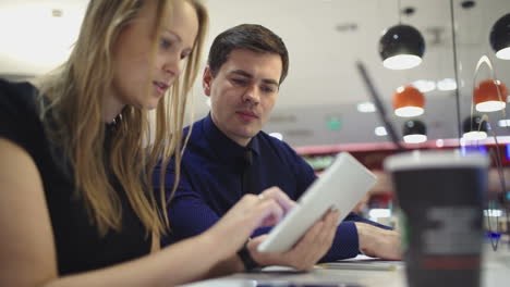 Friends-or-business-partners-with-pad-in-cafe