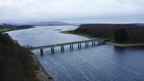 bridging horizons: viaje aéreo al puente de baltyboys sobre el río liffey en las montañas de wicklow, en medio de un viaje nocturno nublado