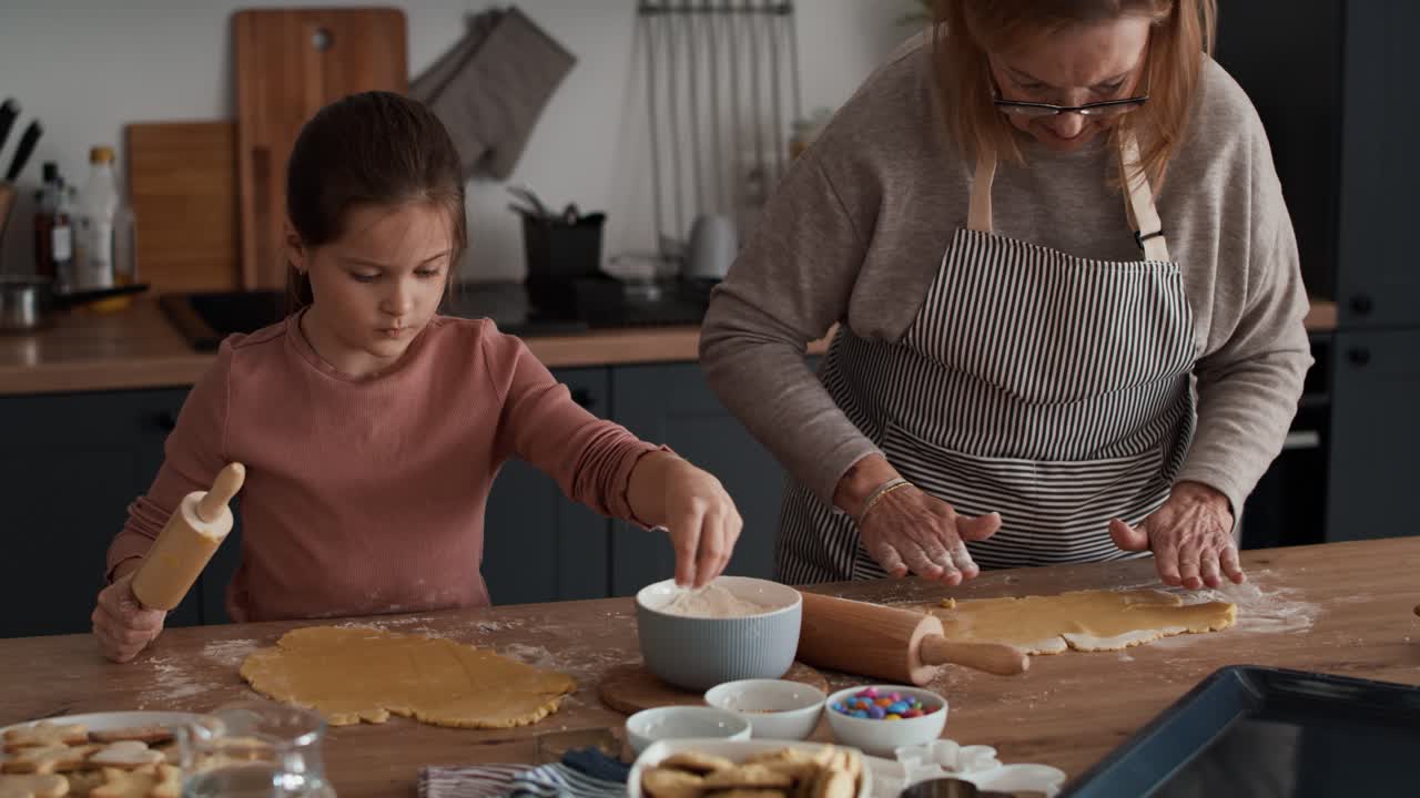 Caucasian girl preparing homemade cookies with grandmother
