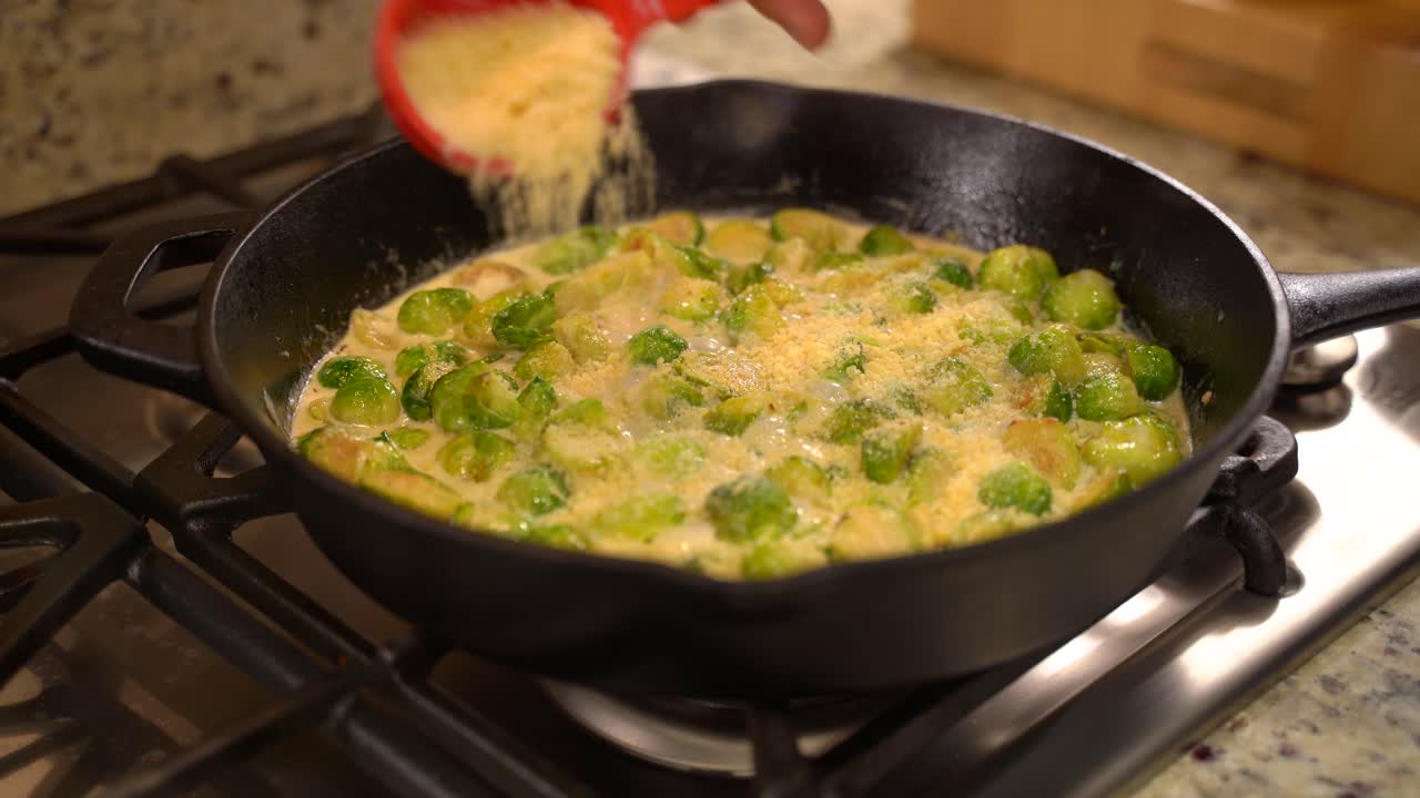 Cooking Roasted Sautéed Brussels Sprouts in a Cast Iron Pan Skillet - Sprinkling Parmesan out of Measuring Cup