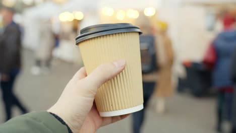 girl holds plastic coffee cup on a busy street, commercial background