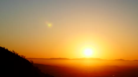 Hermosa-Puesta-De-Sol-Dorada-Con-Niebla-En-La-Cima-De-La-Montaña,-Townsville,-Colinas-Del-Castillo,-Australia